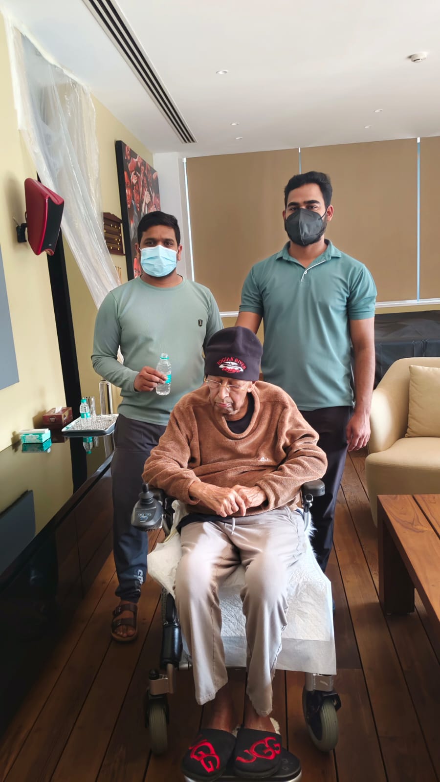 Two caregivers assisting a patient in a wheelchair